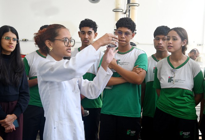 Foto mostra mulher de jaleco branco com o objeto na mão