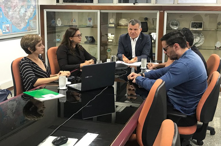 Equipe reunida em uma mesa com o superintendente na cabeceira