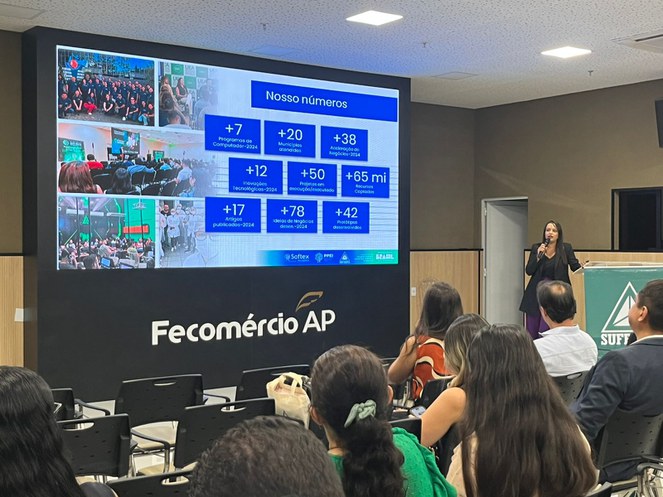 Foto mostra mulher ministrando uma palestra com microfone na mão