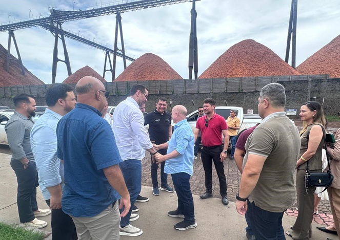 Foto mostra pessoas se encontrando com porção grande de grãos ao fundo