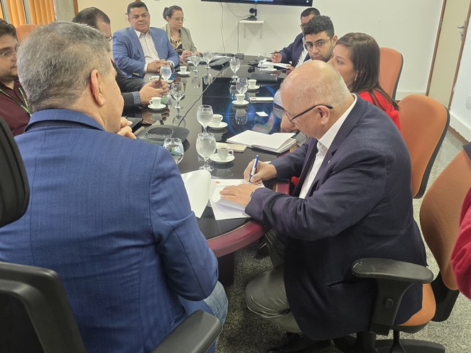 Foto mostra homem assinando documento