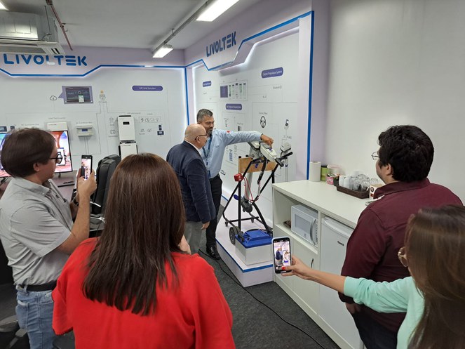 Foto mostra homem mostrando um equipamento a outro homem