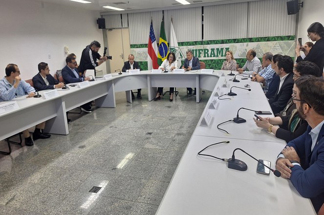 Foto mostra homem de blazer azul falando durante uma reunião