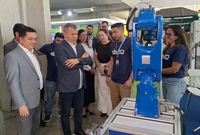 Foto mostra pessoas olhando para um máquina