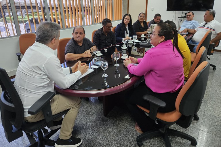 Grupo de pessoas reunidos em uma grande mesa