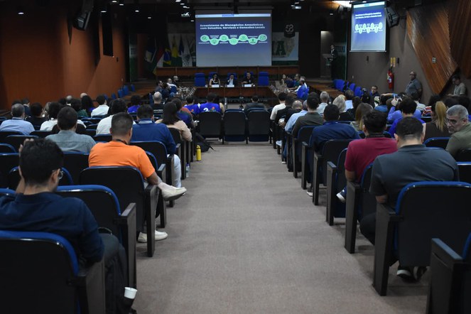 Foto mostra um auditório lotado