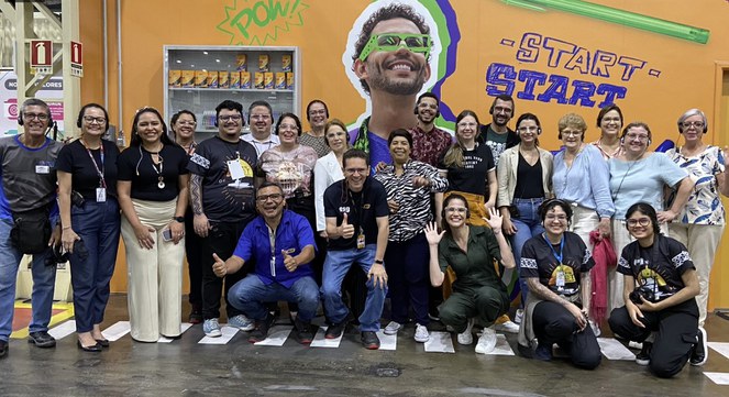 Imagem do grupo reunido em frente a um painel durante a visita na BIC