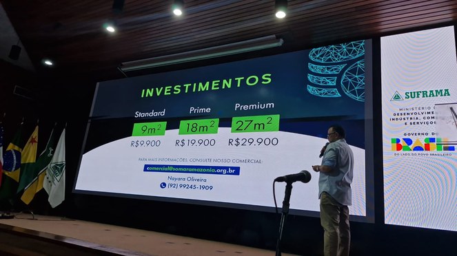 Foto mostra homem fazendo explanação com telão como apoio