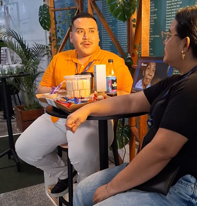 Foto mostra homem e mulher sentados à mesa