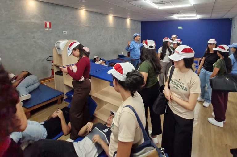 Foto mostra grupo de pessoas em pé e deitadas, com boné na cabeça