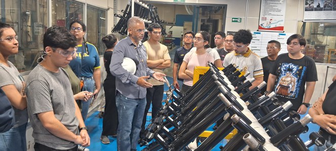 Foto mostra pessoas olhando para peças de bicileta