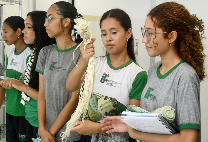 Foto mostra jovem segurando um produto de pesquisa