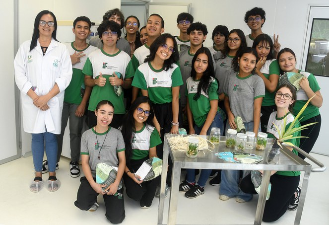 Foto mostra pessoas em frente de produtos posando para foto