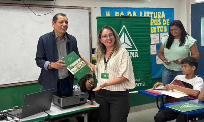 Foto mostra homem e mulher segurando um livro