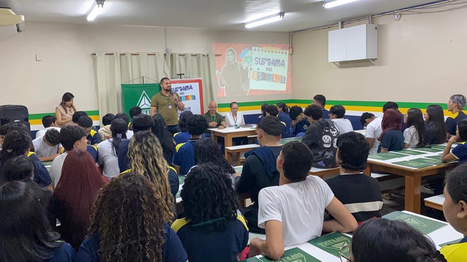 Foto mostra homem em pé falando a grupo de estudantes