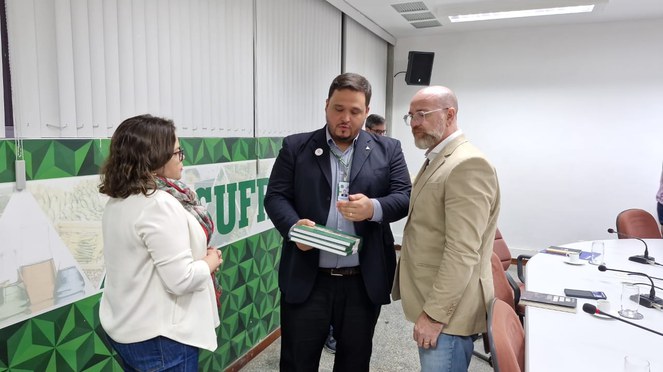 Foto mostra o superintendente-adjunto executivo da Suframa apresentando livro livro sobre a Zona Franca de Manaus