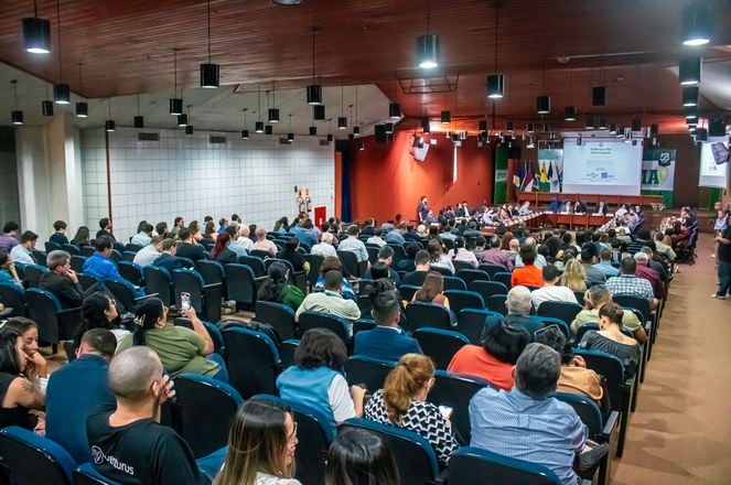 Foto mostra auditório lotado em um evento público
