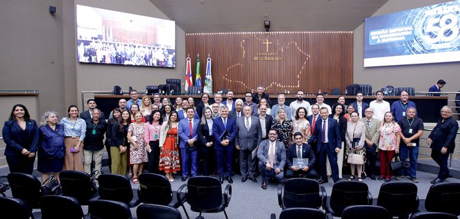 Foto mostra pessoas reunidas para uma foto após sessão solene