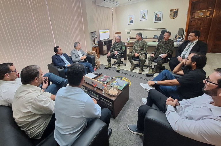 Foto mostra grupo de homens formados com farda do Exército em reunião com civis