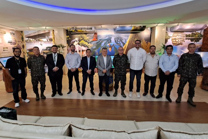 Foto mostra grupo de homens formados com fardas do Exército em reunião com civis