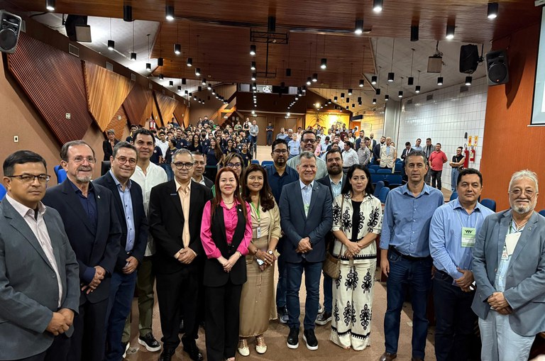 Foto mostra pessoas reunidas num grande auditório