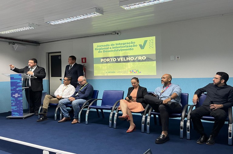 Foto mostra homem em pé falando em público