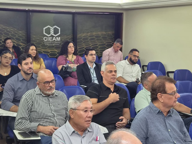 Foto mostra pessoas sentadas num auditório