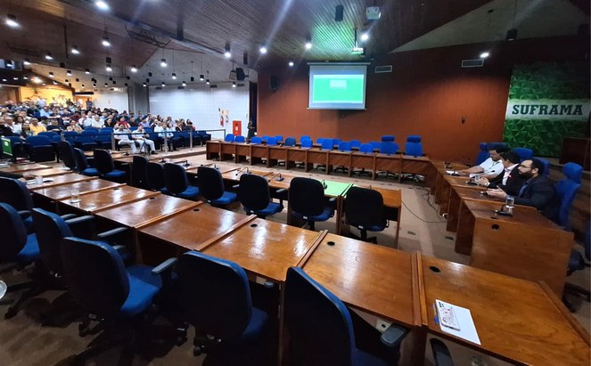 Foto mostra homem de barba fazendo explanação em um auditório