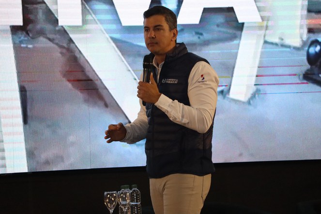 Foto mostra homem falando ao microfone