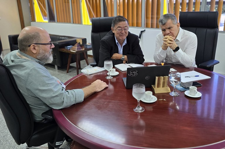 Foto mostra homens olhando para um notebook