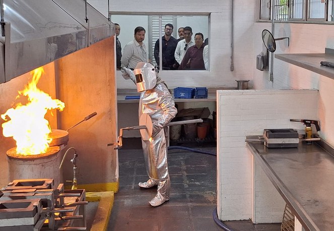 Foto mostra homem manuseando equipamento num equipamento com fogo