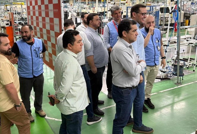 Foto mostra pessoas olhando para máquinas