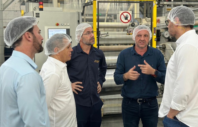 Foto mostra pessoas de touca branca conversando