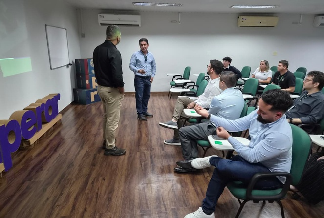 Foto mostra pessoas conversando numa sala