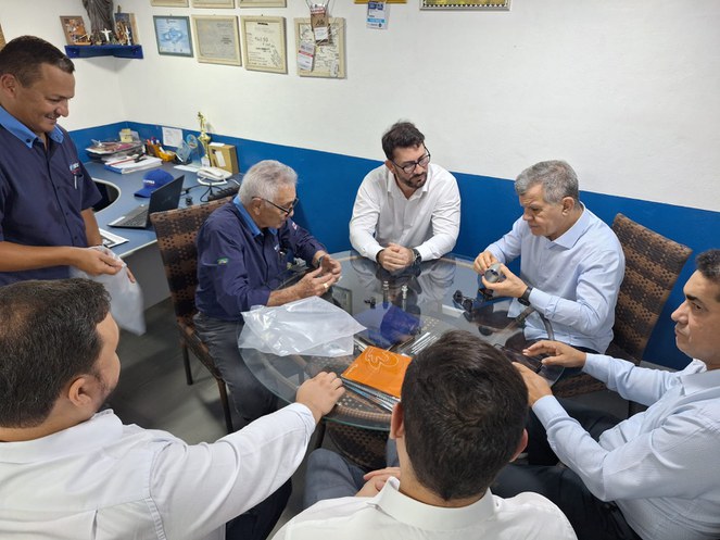 Foto mostra homens verificando peças para veículos de duas rodas