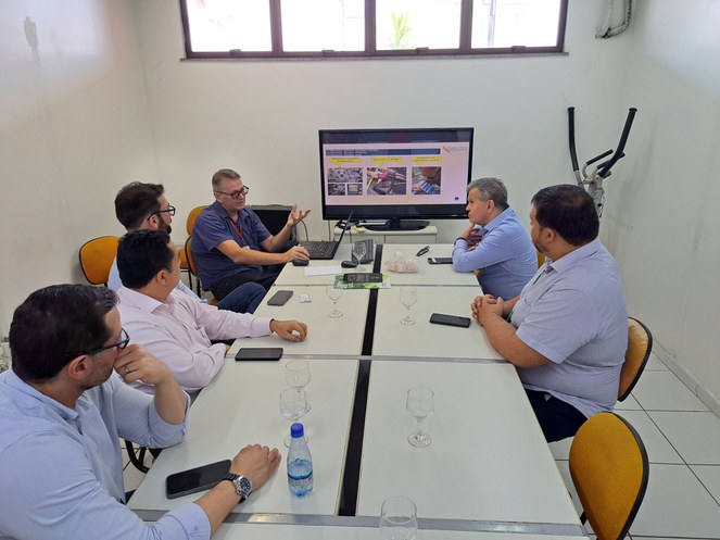 Foto mostra um grupo de pessoas numa reunião