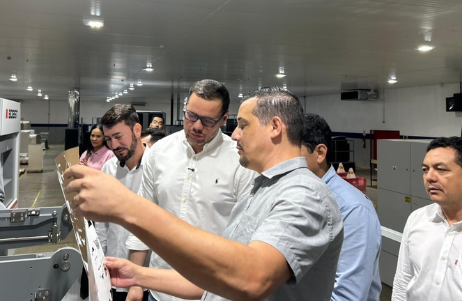 Foto mostra homem manuseando produto de embalagens em uma fábrica