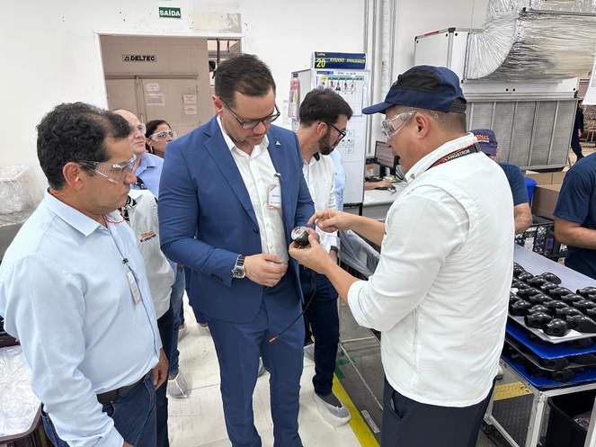 Foto homem mostrando peça de luminárias automotivas