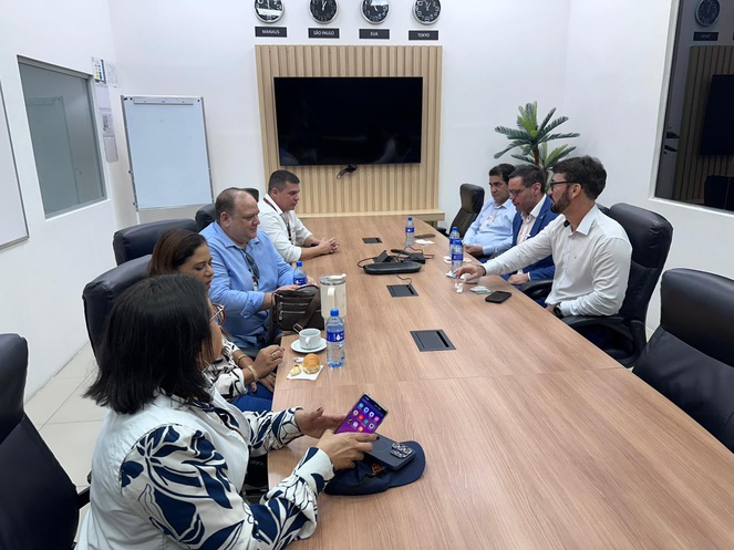 Foto mostra pessoas sentadas à mesa durante uma reunião
