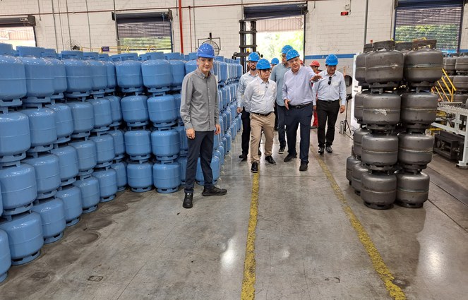 Foto mostra homens de capacete azul em fábrica de botijas de gás