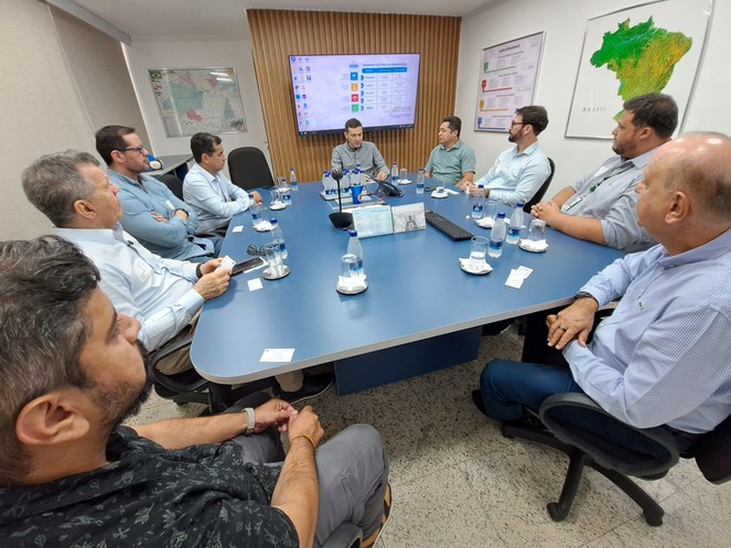Foto mostra homens sentados à mesa
