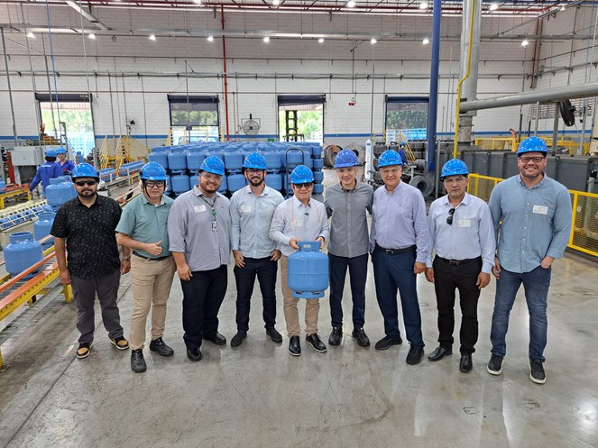 Foto mostra homem de capacete azul segurando uma botija de gás