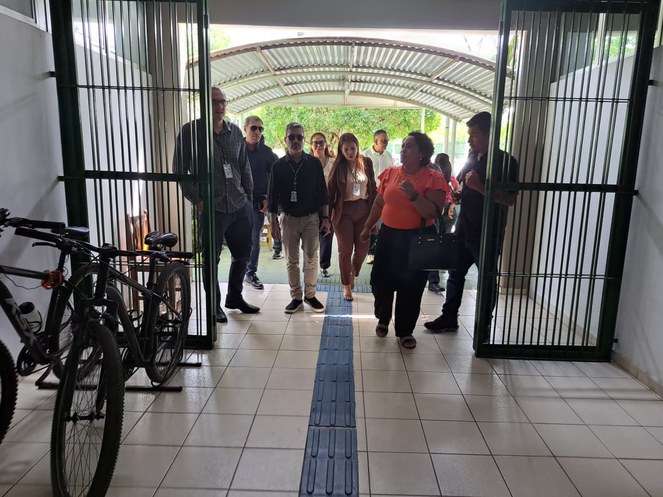 Foto mostra pessoas entrando por uma porta