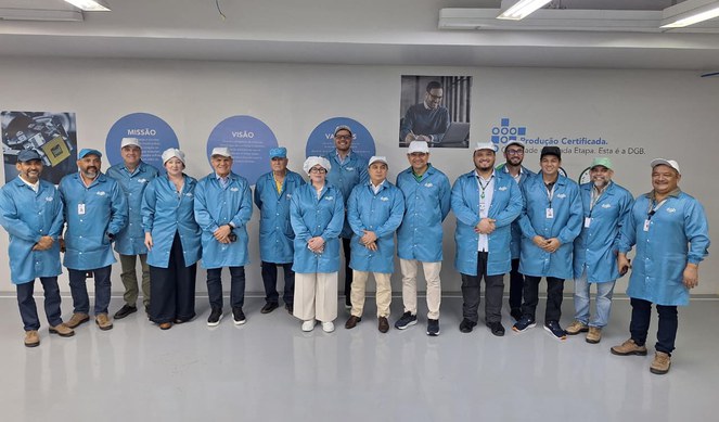 Foto mostra grupo de pessoas de bata azul posando para uma sessão de foto