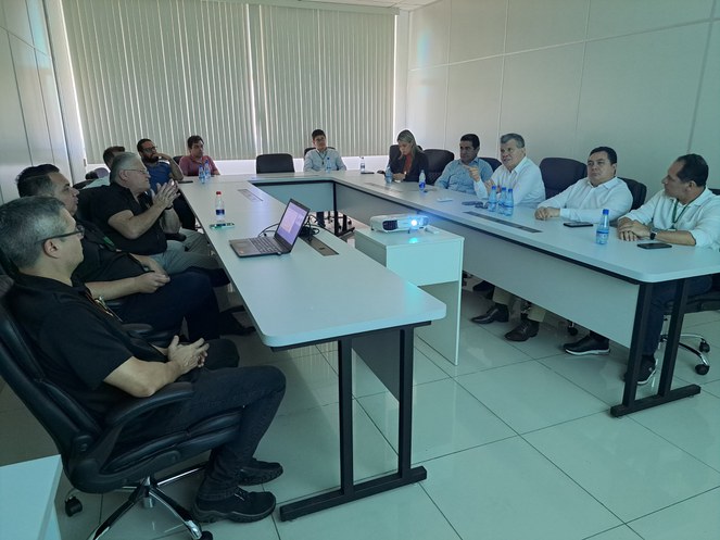 Foto mostra um grupo de pessoas reunidas em volta de uma mesa
