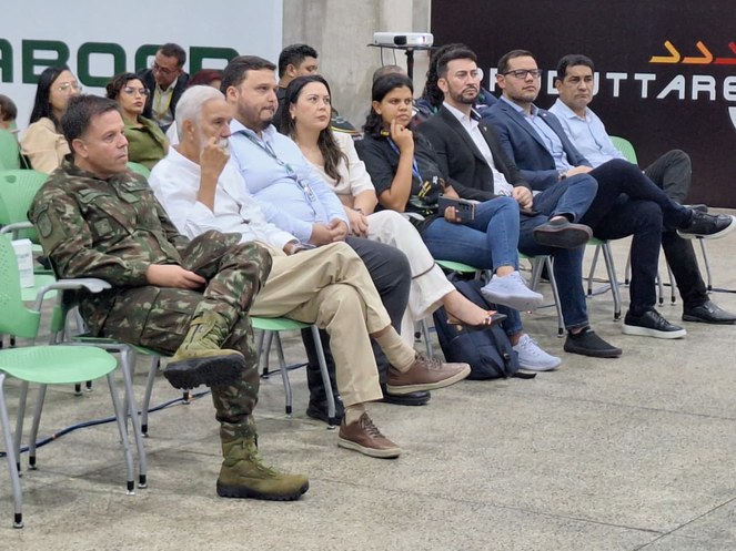 Foto mostra pessoas sentadas em um eventonto