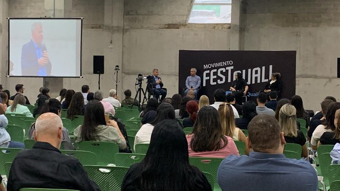 Foto mostra auditório cheio em um evento