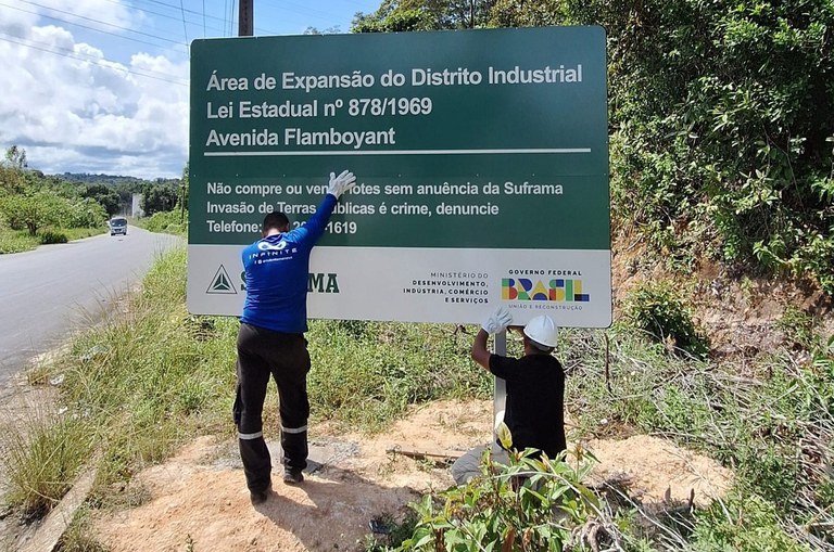 Foto mostra trabalhadores instalando placa da Suframa em Área de Expansão do Distrito Industrial