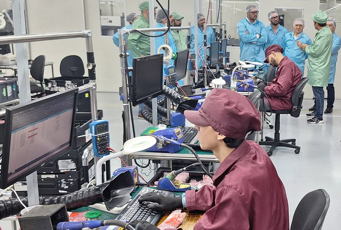 Foto mostra pessoas de bata em uma empresa