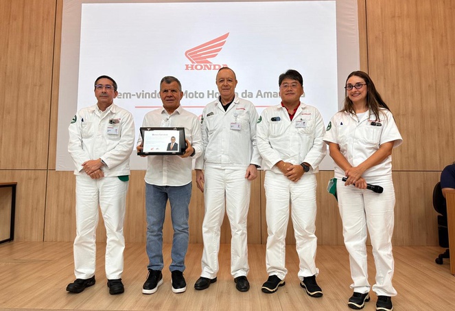 Foto mostra uma pessoa segurando uma placa no meio de outras pessoas